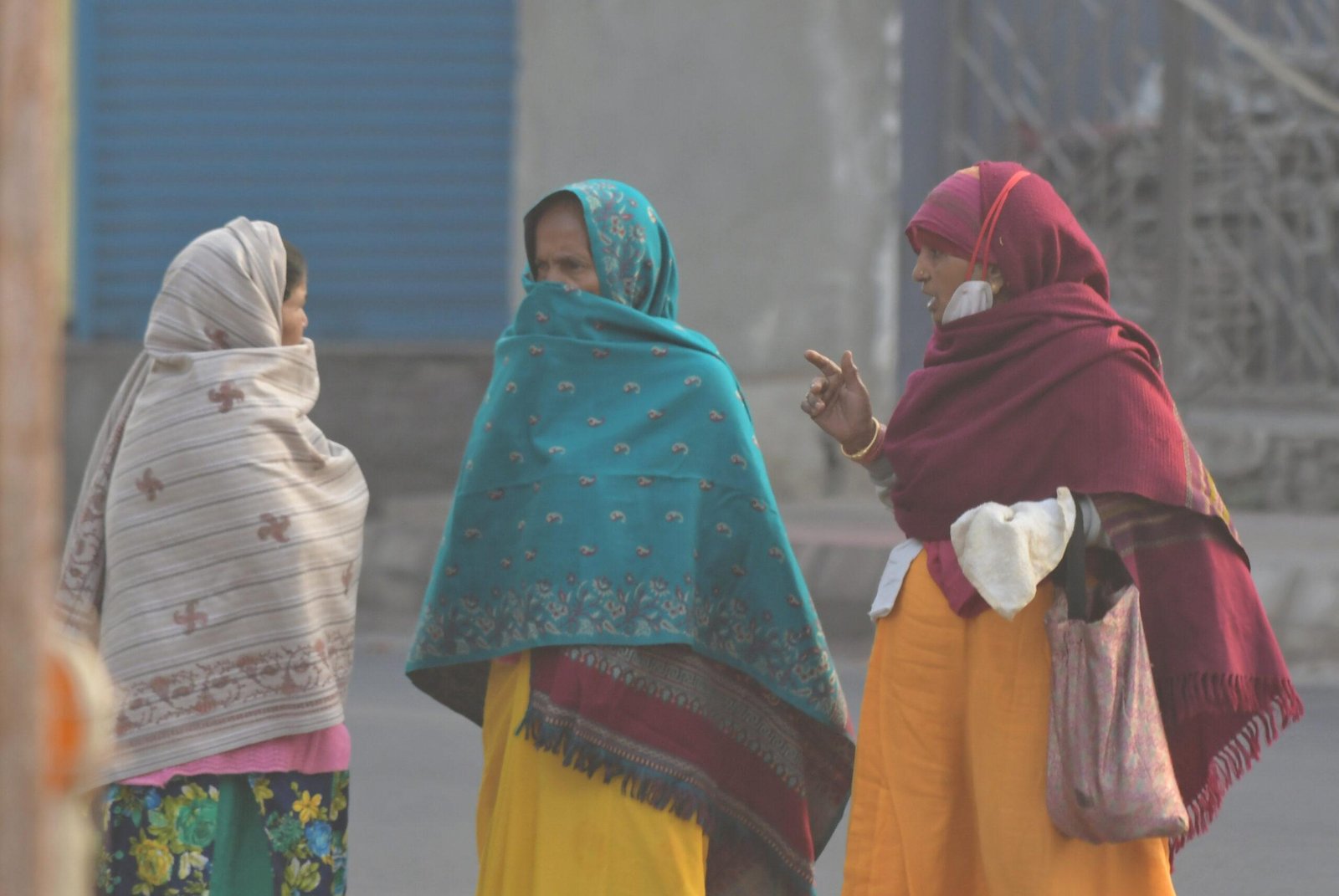 Women wrapped in warm clothes as cold wave sweeps capital