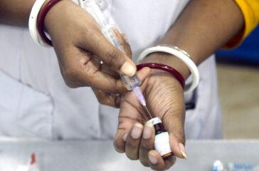A health worker fills a syringe with measles and rubella vaccine to inoculate a student during a MR vaccination drive in Kolkata