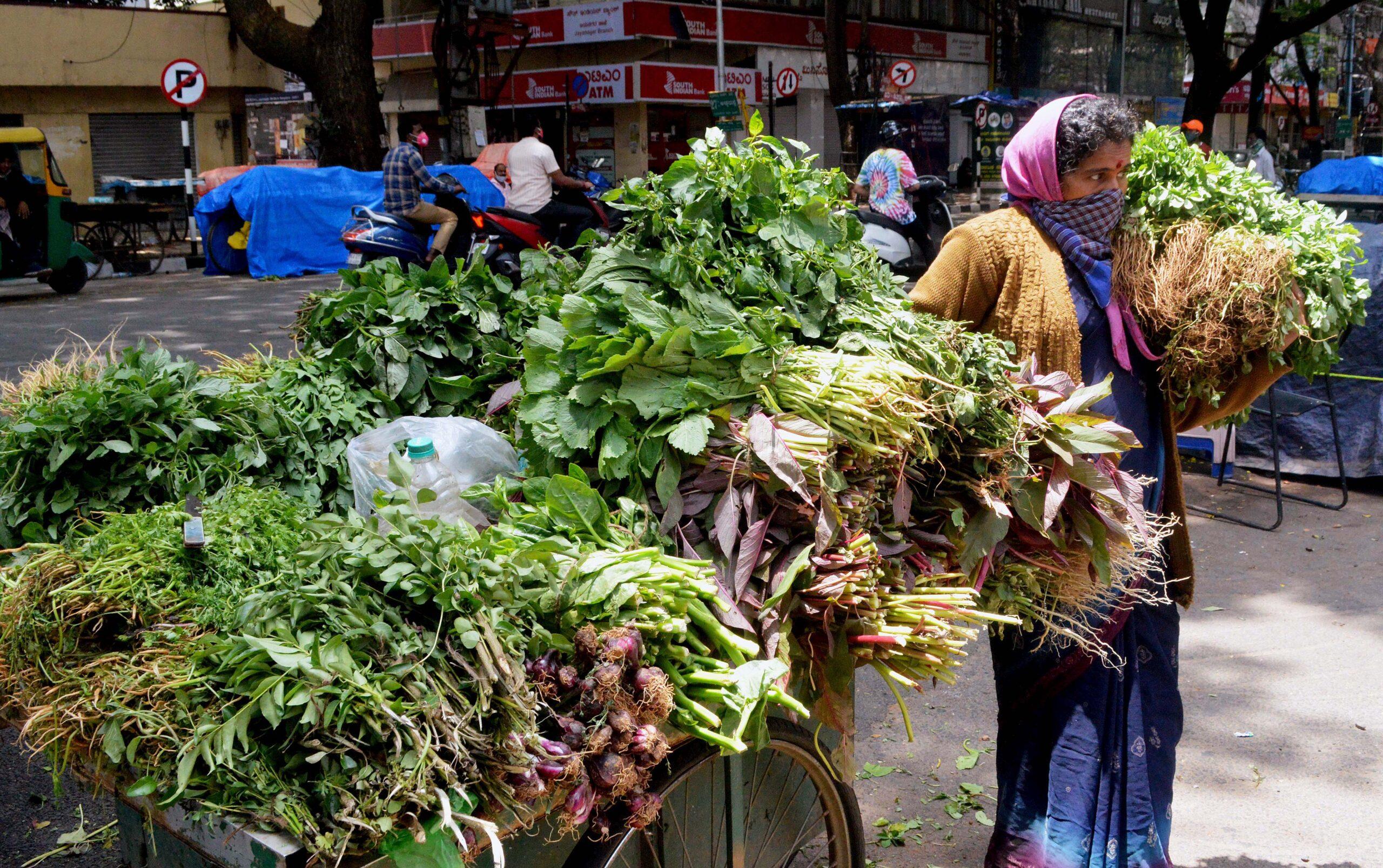 A woman street vendor sells vegetables during lockdown
