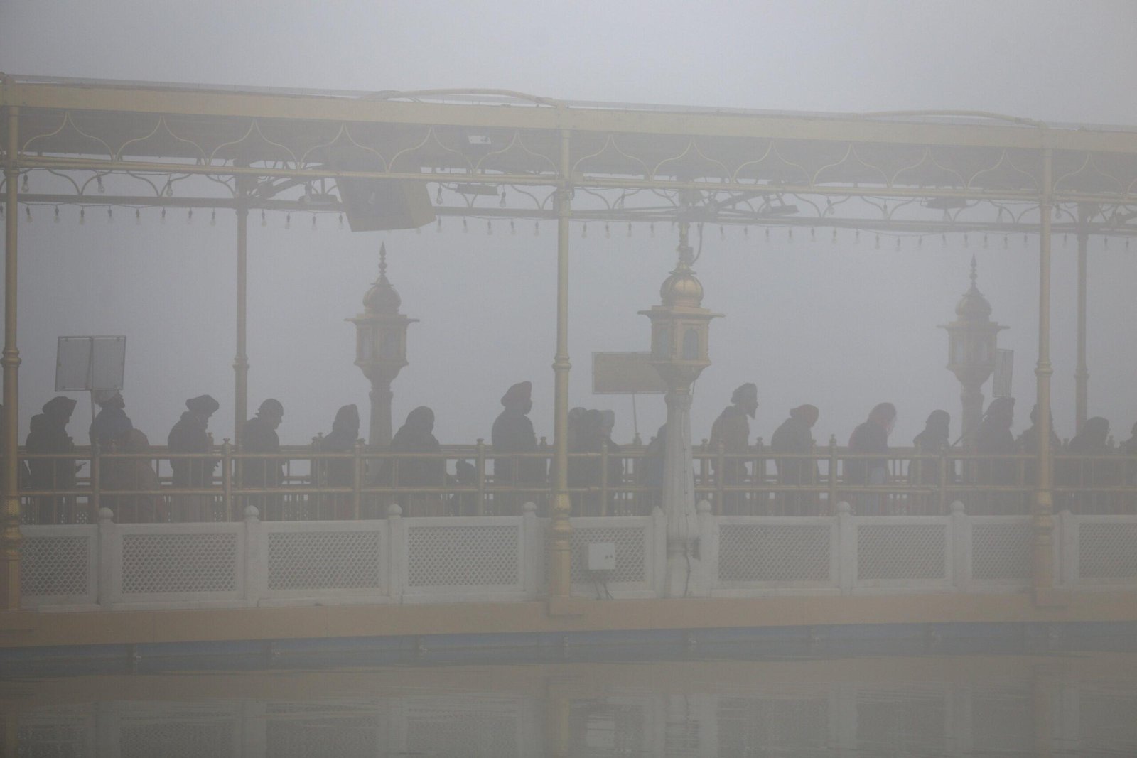 Devotees stand in a queue on the path towards the Golden Temple amid dense fog Devotees stand in a queue on the path towards the Golden Temple amid dense fog