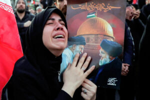 A woman mourns the killing of Iran's Supreme Leader Ayatollah Ali Khamenei in Israeli-US strikes as people gather at the Enghelab Square