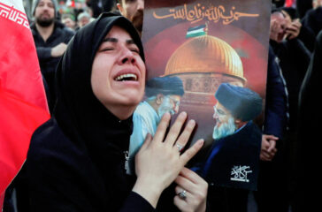 A woman mourns the killing of Iran's Supreme Leader Ayatollah Ali Khamenei in Israeli-US strikes as people gather at the Enghelab Square