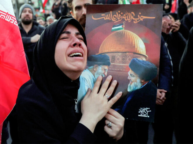 A woman mourns the killing of Iran's Supreme Leader Ayatollah Ali Khamenei in Israeli-US strikes as people gather at the Enghelab Square